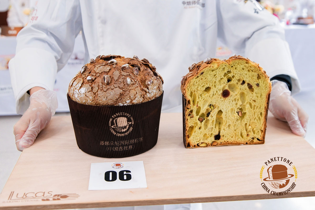 two panettone being presented inside novacart baking molds on a wooden surface